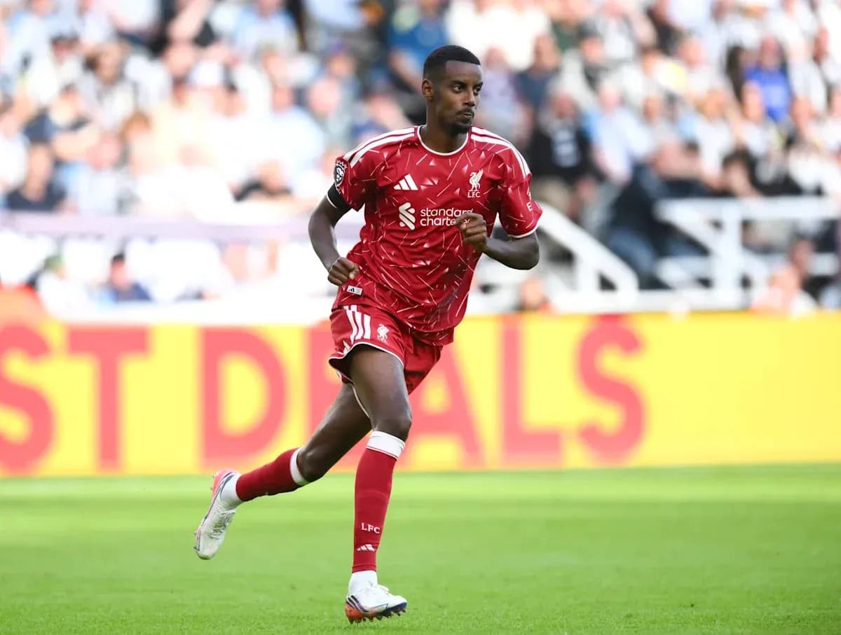 Player running on the pitch in red kit Player running on the pitch in red kit